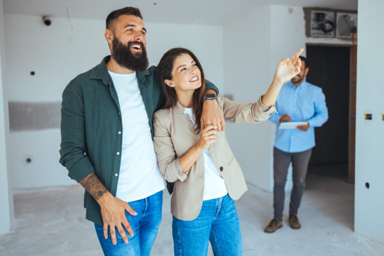 Joyful Caucasian Couple in New Apartment with Real Estate Agent